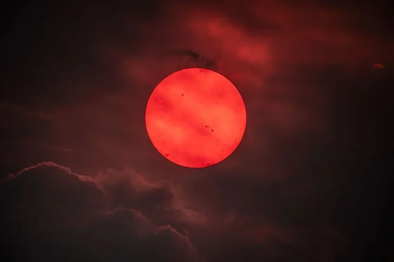 Eerie Red Sun Over British Columbia: Wildfire Smoke Transforms Our Star into an Exoplanet Vision, Revealing Active Sunspots